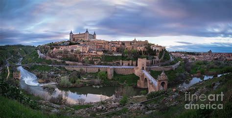 A panoramic view of Toledo, Spain, sitting on a hill surrounded by the Tagus River.